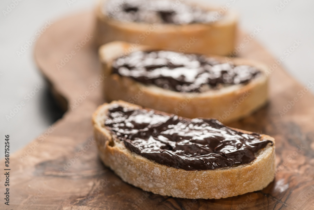 Rustic ciabatta with organic chocolate cream on olive wood board Rustic ciabatta with organic chocolate cream on olive wood board