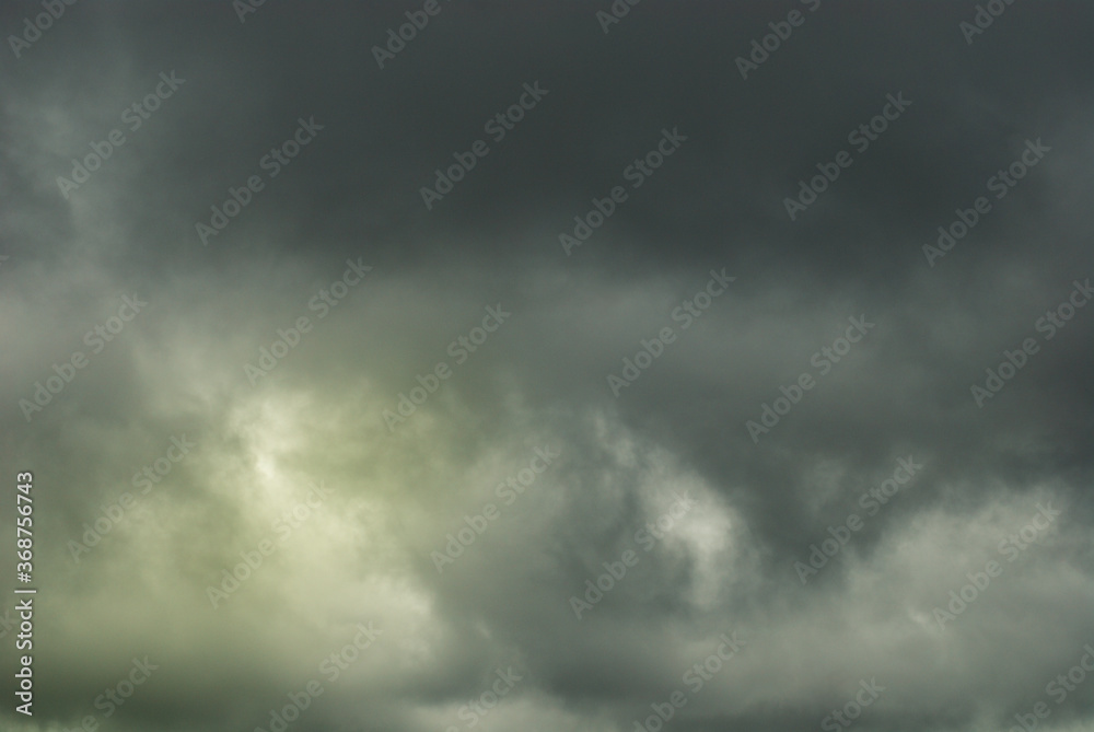 Light and shadow of natural toned emotional day sky background. Heavy cloud formation in stormy dark sky, strong wind and hard rain. Rainy season day atmosphere.