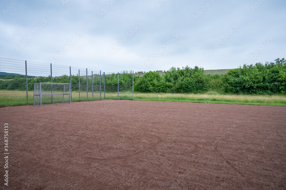 soccer field with metal goal and metal fence for youngsters to play