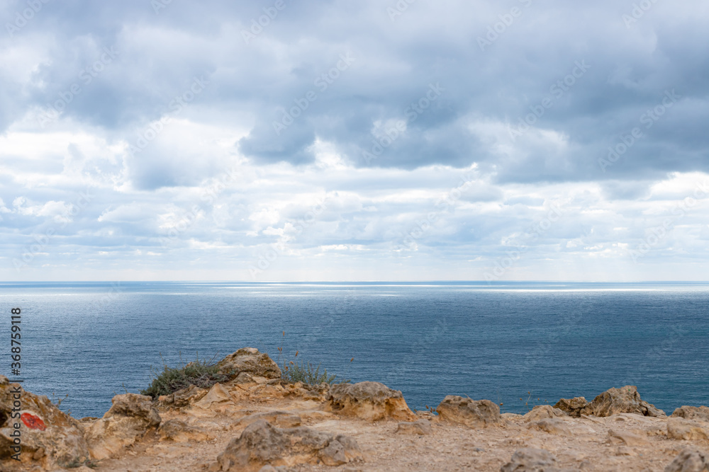 stone ledge into the sea. Calm blue sea and sky with clouds. Concept of nature background. stone ledge into the sea. Calm blue sea and sky with clouds. Concept of nature background.