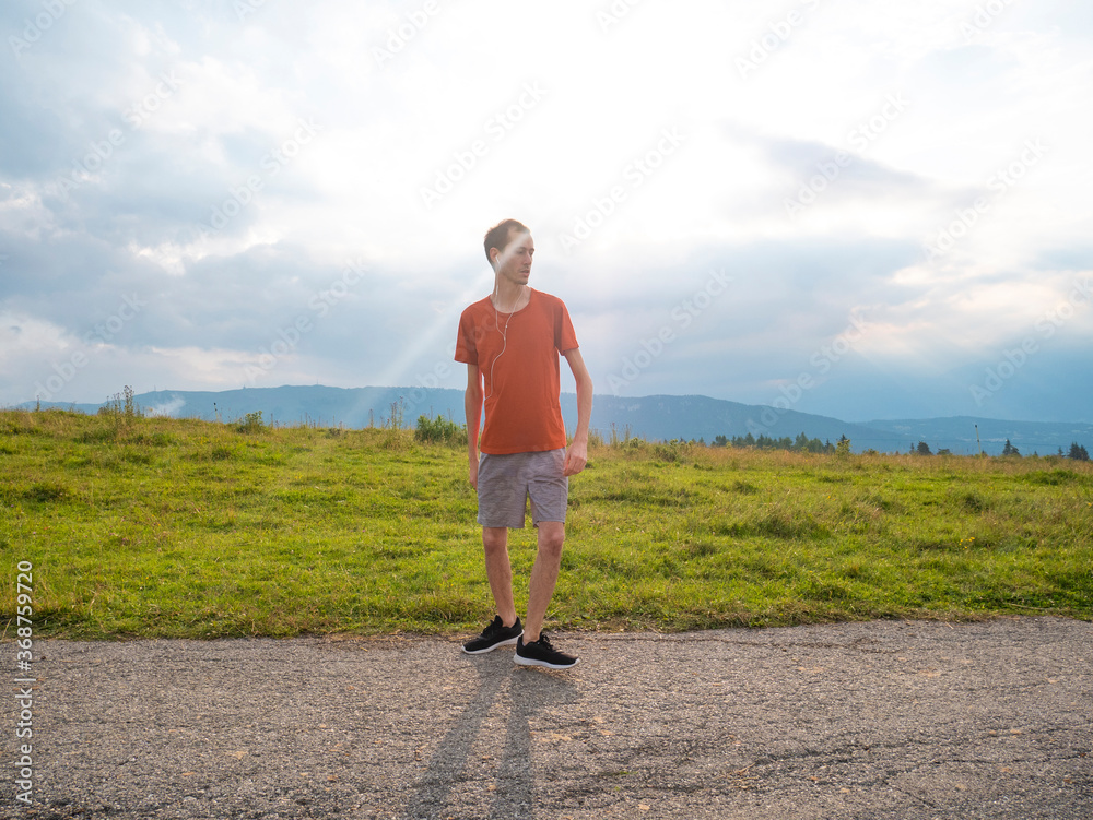 Obraz premium young runner man warms up for running on the hill in nature