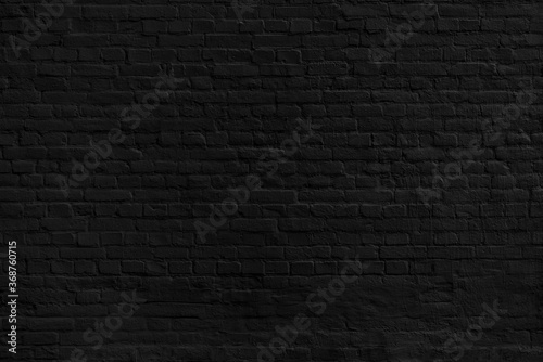 The background of the old black brick wall for design interior and various scenes or as a background for video interviews.