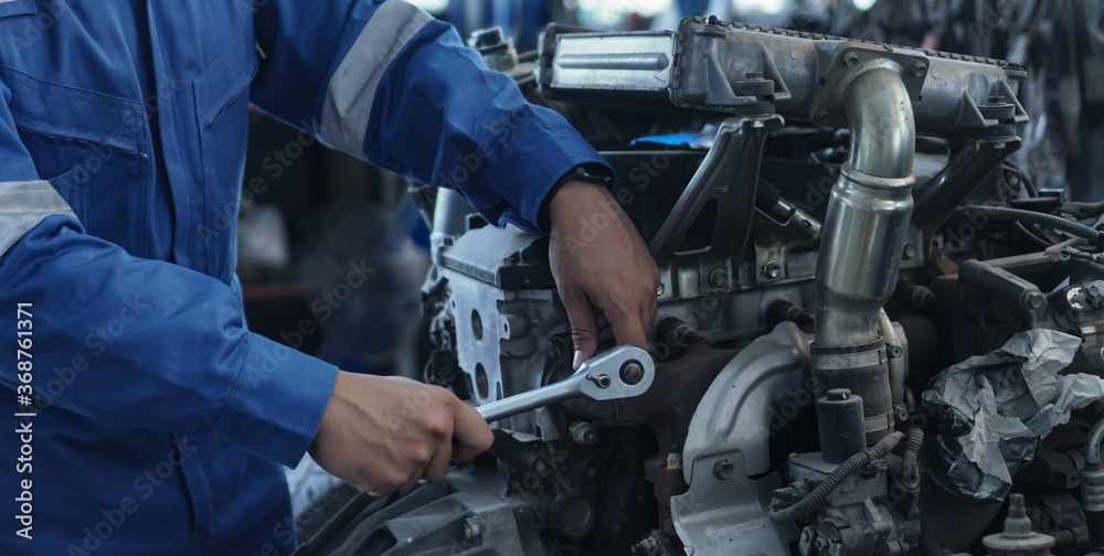 Mechanic auto mechanic in uniform repairing.car in auto machine tools ready to be used with car service.selective focus. Mechanic auto mechanic in uniform repairing.car in auto machine tools ready to be used with car service.selective focus.