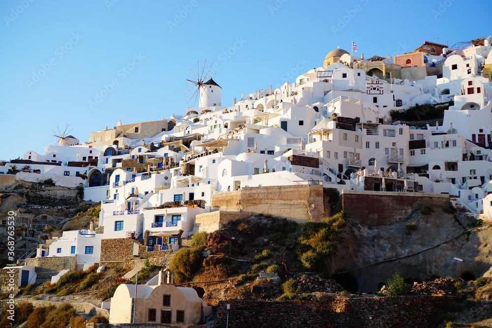 Fototapeta premium Sunset lights up the beautiful city, Thira, Greece, Europe