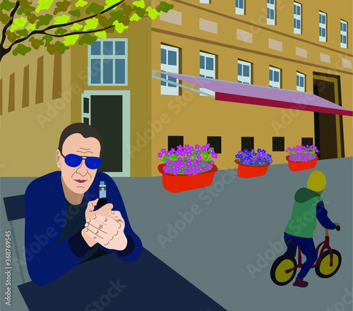 A man with an electronic cigarette sits in a street cafe, in the background is a building, a boy rides a bicycle