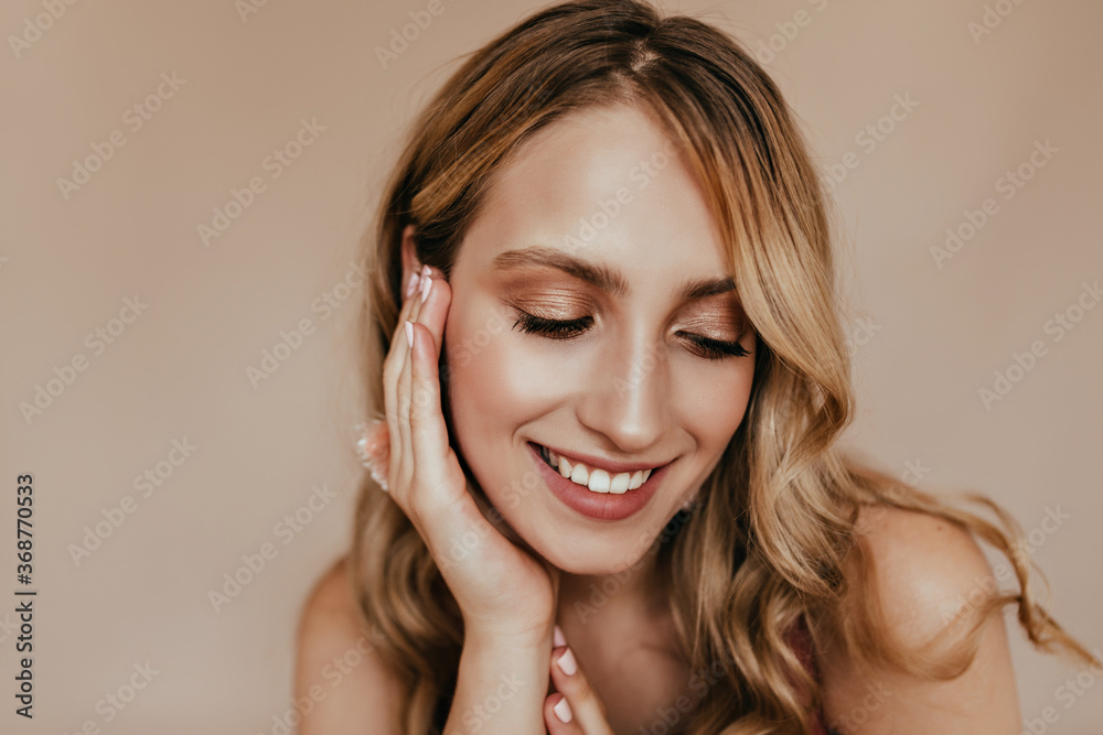 Close-up portrait of pleasant white woman with shiny makeup. Studio photo of chilling blonde girl with beautiful smile.