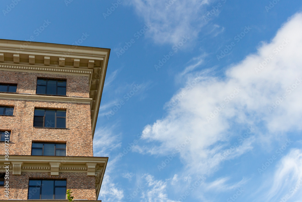 Low angle view of brick building. Blue sky with some clouds. Copy space for your text. Architecture theme.