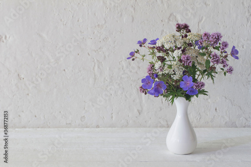 Fototapeta Naklejka Na Ścianę i Meble -  wild flowers in white vase on white background
