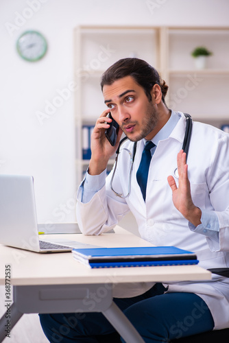 Young male handsome doctor working in the clinic