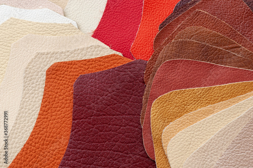 Colorful background of multi-colored pieces of genuine leather of different textures, color swatches for choice