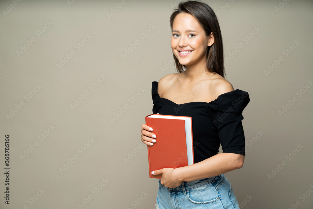 smiling beautiful student girl with a large book in her hands smiling beautiful student girl with a large book in her hands
