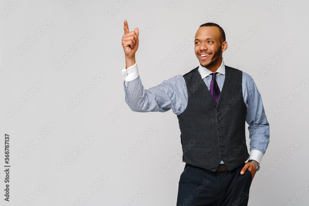 African-American businessmanman showing up by finger over grey background African-American businessmanman showing up by finger over grey background