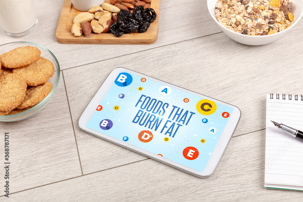 Healthy Tablet Pc compostion with FOODS THAT BURN FAT inscription, weight loss concept Healthy Tablet Pc compostion with FOODS THAT BURN FAT inscription, weight loss concept