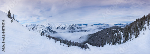 Winter panorama landscape in the Karwendel mountains at Schafreiter, with fog, snow and forest. © Bastian Linder