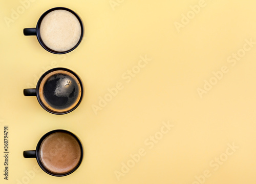 Many mugs with different types of coffee: cappuccino, espresso, coffee with milk. With copy space