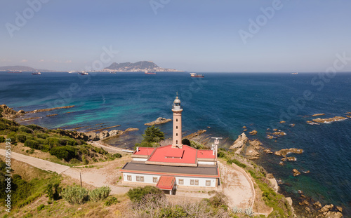 Aerial view from Punta Canero lighthouse. There are large cargo and commercial ships in the bay. Behind it is the British Rock of Gibraltar.