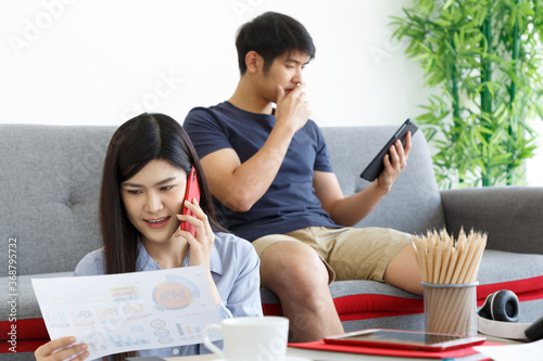 Two young couple business people making Phone Call. working Online Business on Messing Table. Work From Home Concept.