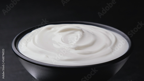 Bowl of sour cream on black background