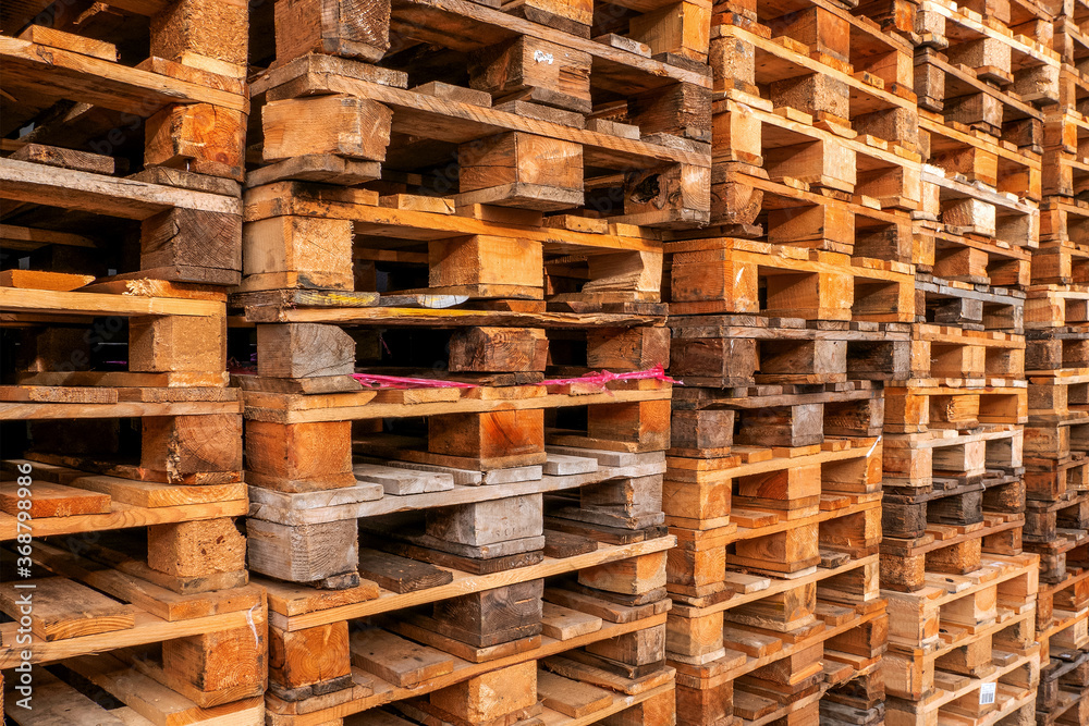 Many stacks of used  wooden pallets of euro type on warehouse is ready for recycling. Industrial background. Close-up.