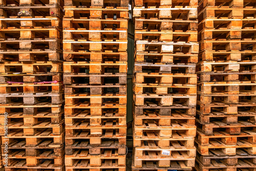 A lot stacks of used  wooden pallets of euro type on warehouse is ready for recycling. Industrial background. Close-up.
