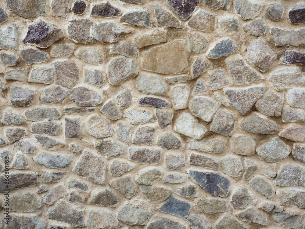 Mosaic pattern of stones, cement. Stone wall. Texture of grey granite. Uneven rock surface of floor, decorative tile of facade building. Mosaic pattern of stones, cement. Stone wall. Texture of grey granite. Uneven rock surface of floor, decorative tile of facade building.