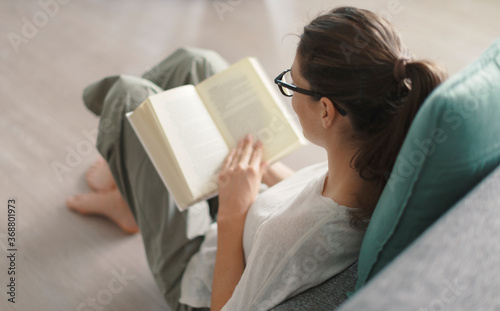 Woman relaxing at home and reading a book