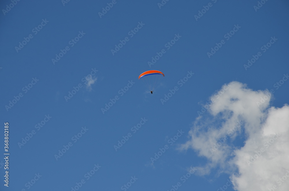 Paraglider pilots in Talloires-Montmin area near Annecy in Upper Savoy (Haute Savoie), France, blue sky background with clouds, a sunny day in summer Paraglider pilots in Talloires-Montmin area near Annecy in Upper Savoy (Haute Savoie), France, blue sky background with clouds, a sunny day in summer