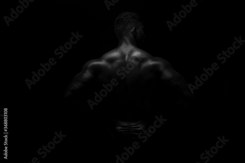 Silhouette of young athlete bodybuilder man on black © sameer
