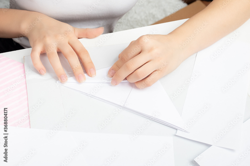 Young woman makes paper figures. Hobby concept