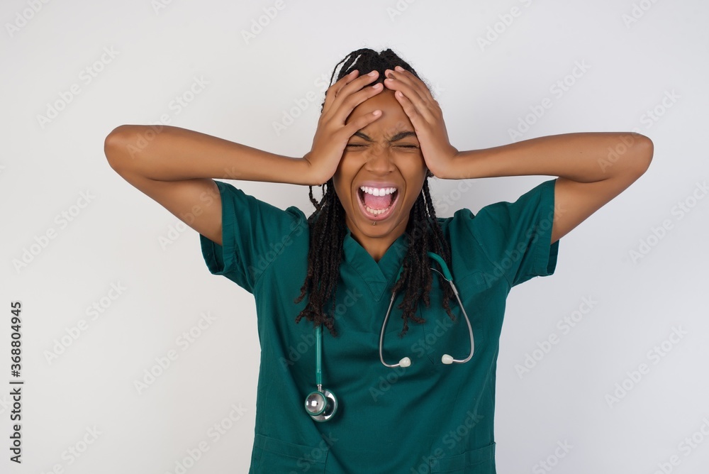 Shocked panic Caucasian doctor girl holding hands on head and screaming in despair and frustration while being late for plane, her eyes full of terror, mouth dropped. Shocked panic Caucasian doctor girl holding hands on head and screaming in despair and frustration while being late for plane, her eyes full of terror, mouth dropped.