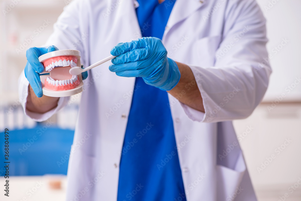 Young male dentist working in the clinic