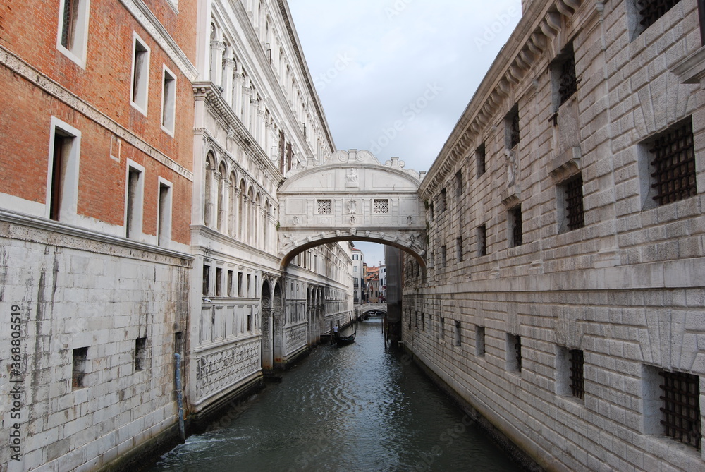 
bridge of sighs in Venice with gondola in the distance