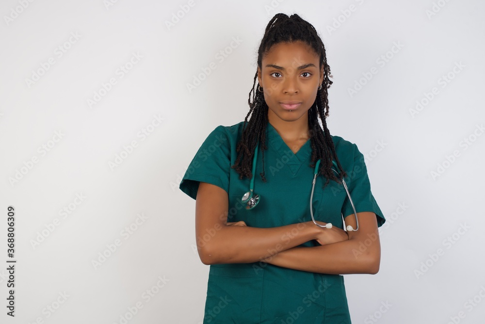 Waist up portrait of beautiful young doctor female with positive expression, has crossed arms, feels happy and confident, wears medical uniform. Waist up portrait of beautiful young doctor female with positive expression, has crossed arms, feels happy and confident, wears medical uniform.