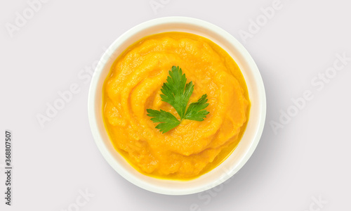 Mashed carrots in white bowl on a white background
