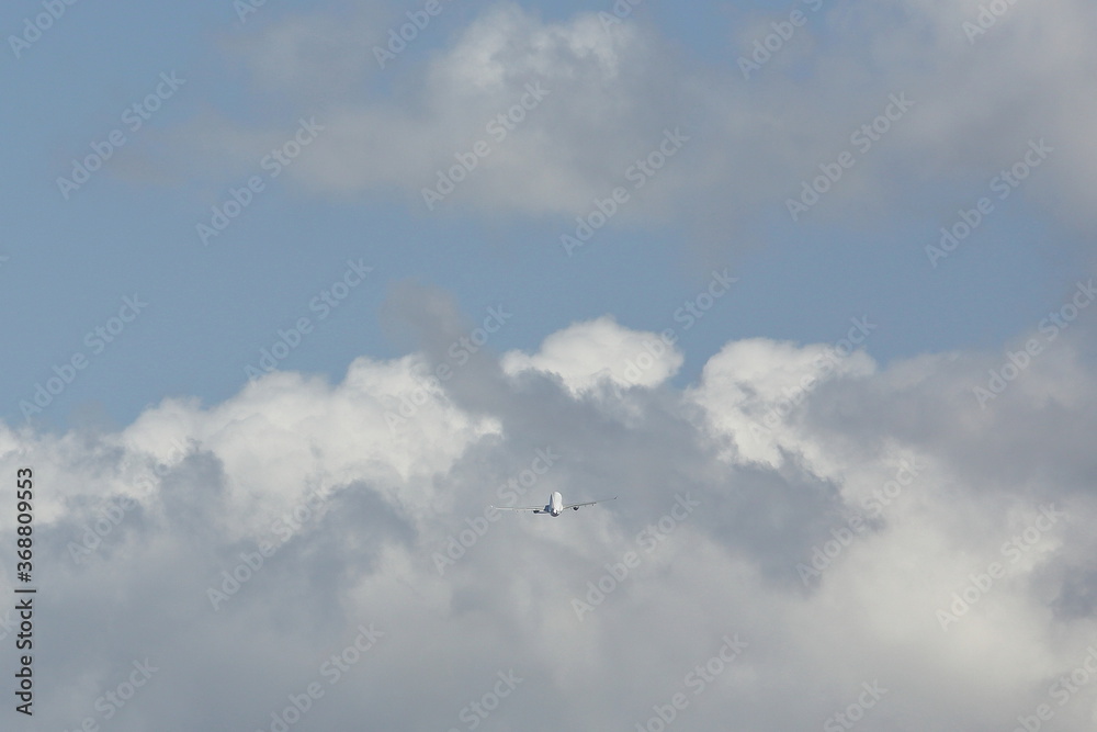 an airplane flying in the sky with cloud