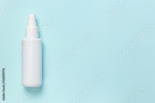 Plastic container  bottle spray liquid white for cosmetics skin antiseptic sanitizer for hand hygiene from viruses  bacteria in a pandemic epidemic of the disease on a blue background with copy space