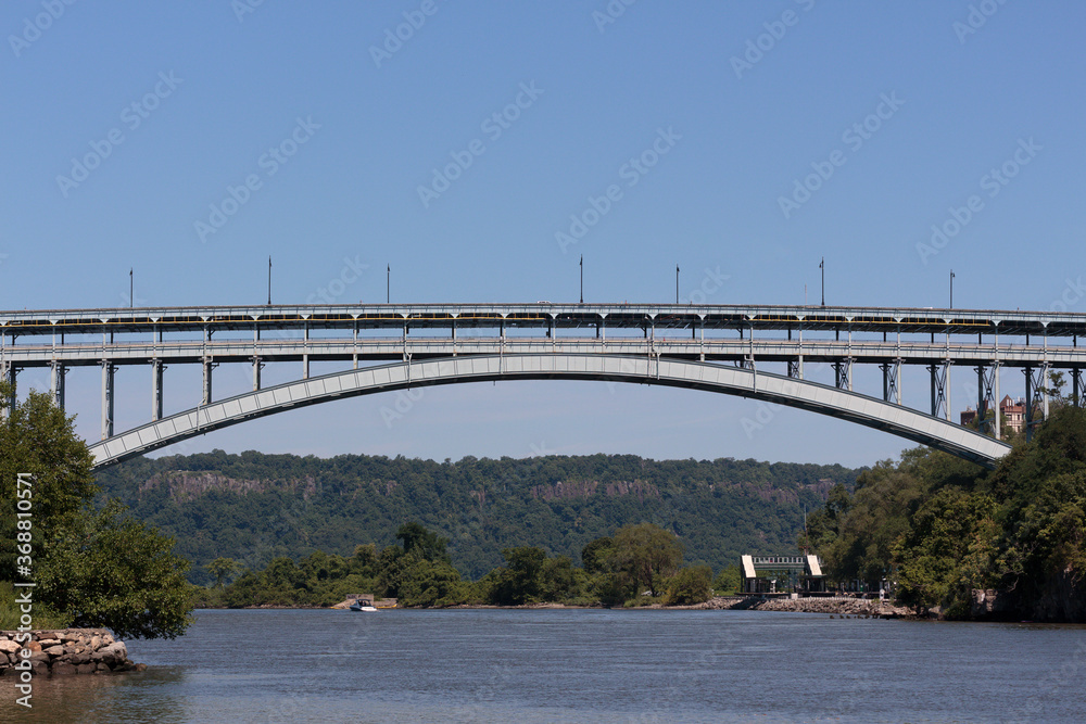Naklejka premium The Henry Hudson Bridge spanning the Spuyten Duyvil Creek connecting the Bronx to Northern Manhattan at Inwood on a sunny day with a clear blue sky