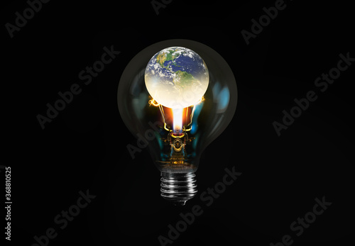 Fototapeta Naklejka Na Ścianę i Meble -  Burning candle in the light bulb with bulb isolated on black background - Light bulb with world inside and global warming isolated on black 