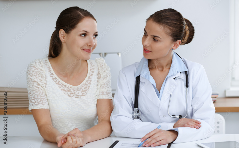 Doctor and patient sitting at the desk. Medicine and health care concept Doctor and patient sitting at the desk. Medicine and health care concept