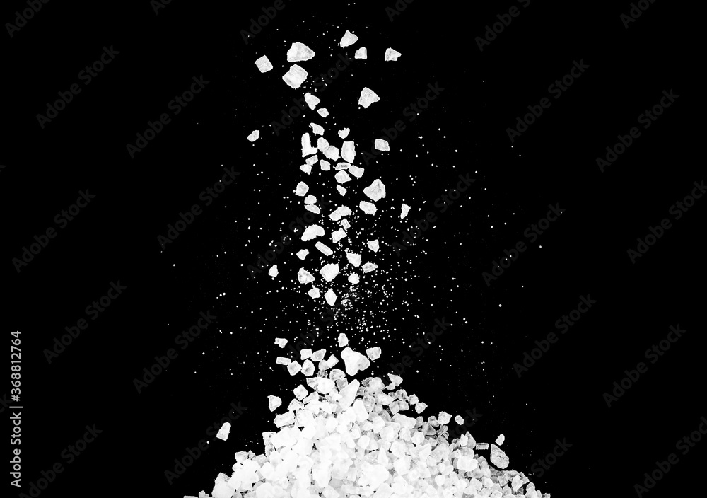 Close-up of macro crystals of sea salt or coarse salt isolated on black background
