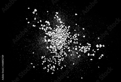 Close-up of macro crystals of sea salt or coarse salt isolated on black background