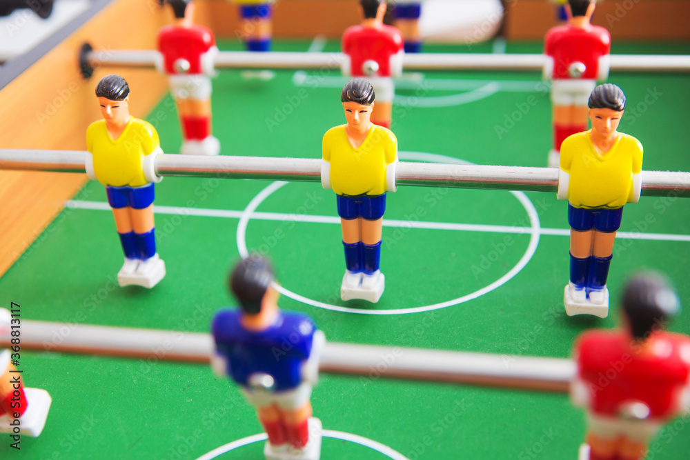 Fototapeta premium Table football game with yellow and red players and white goalkeeper.