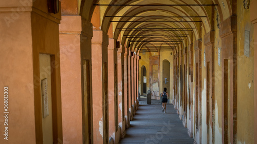 Teen girl running through long Portico in shorts and sneakers