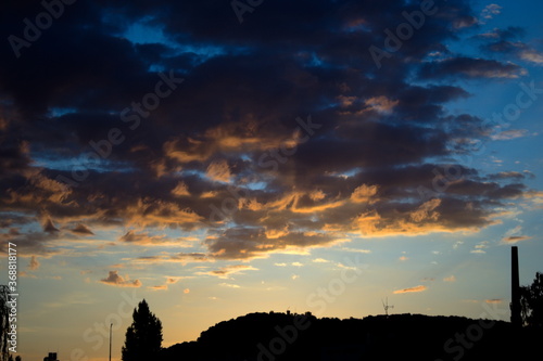 Orange Wolken bei Sonnenaufgang mit Silhouette vom berg