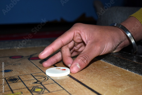 Beautiful picture of hand wile playing carom at home