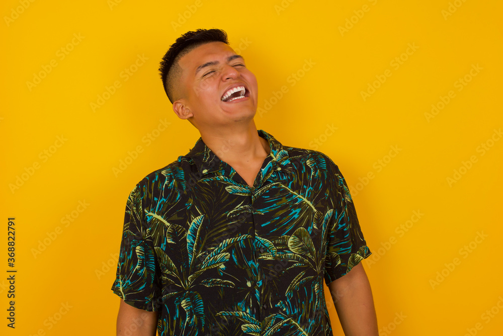 Joyful European man having fun and laughs at good joke or sings wears casual clothes, standing against gray wall. Happy man poses inddoors. Joyful European man having fun and laughs at good joke or sings wears casual clothes, standing against gray wall. Happy man poses inddoors.