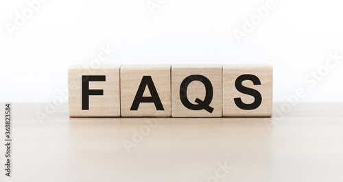text of FAQS on wooden cubes on light background