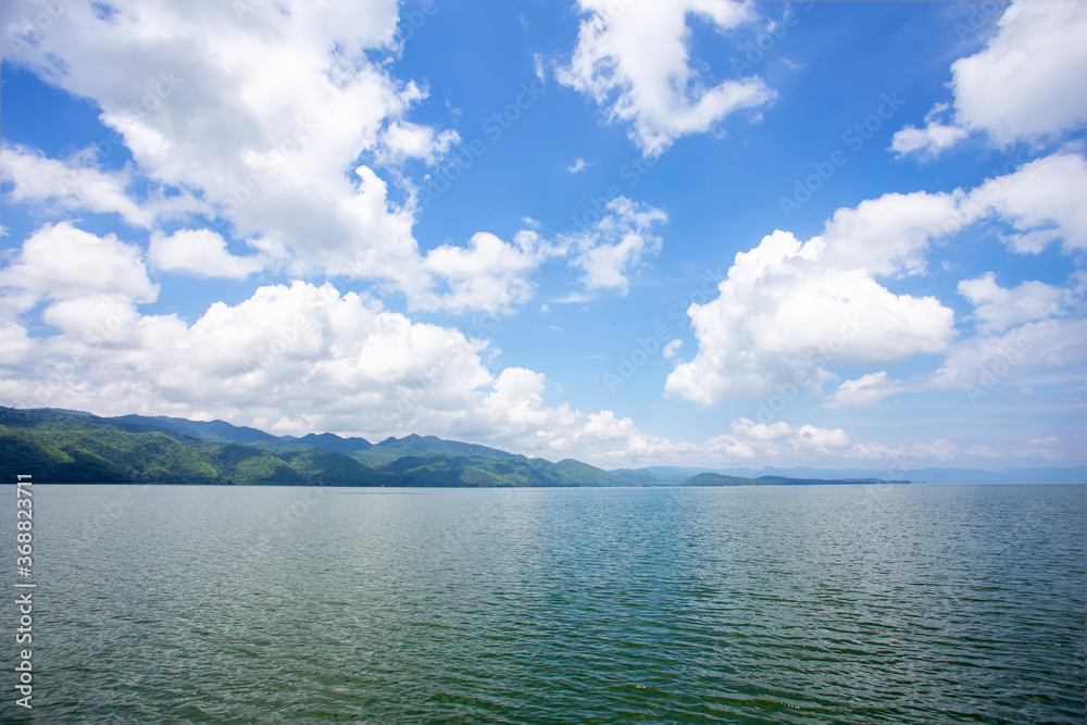 Landscape of the mountain and river with blue sky in the morning. View of the mountain with blue sky at Srinakarin Dam , Kanchanaburi province , Thailand.