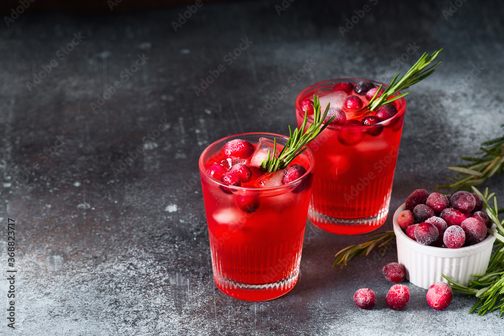 Cranberry drink cocktail with ice and rosemary on dark background Cranberry drink cocktail with ice and rosemary on dark background