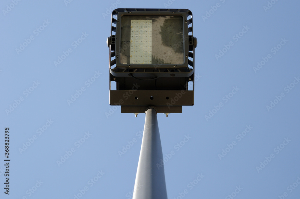 LED floodlight lighting on a metal mast against the blue sky. bottom view. LED floodlight lighting on a metal mast against the blue sky. bottom view.